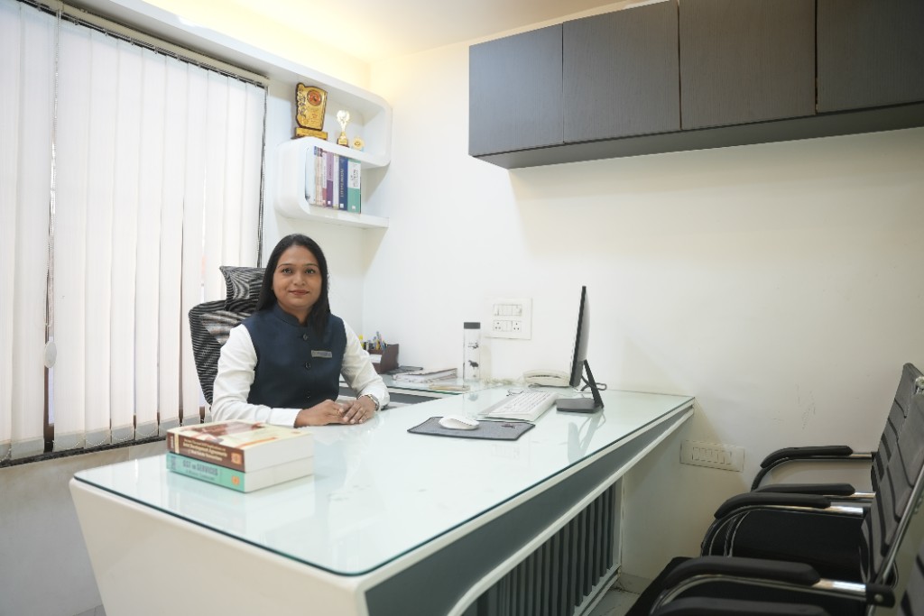 Team member at a modern white desk with reference books and office workspace